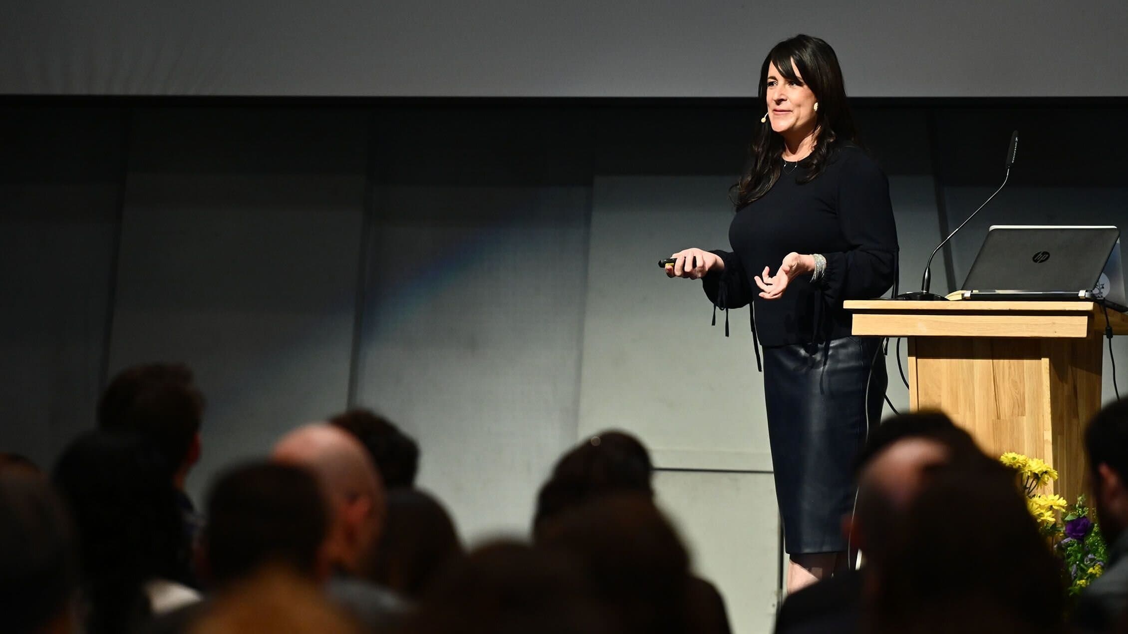 Kristin Skinner delivering a keynote presentation on organizational systems and leadership.
